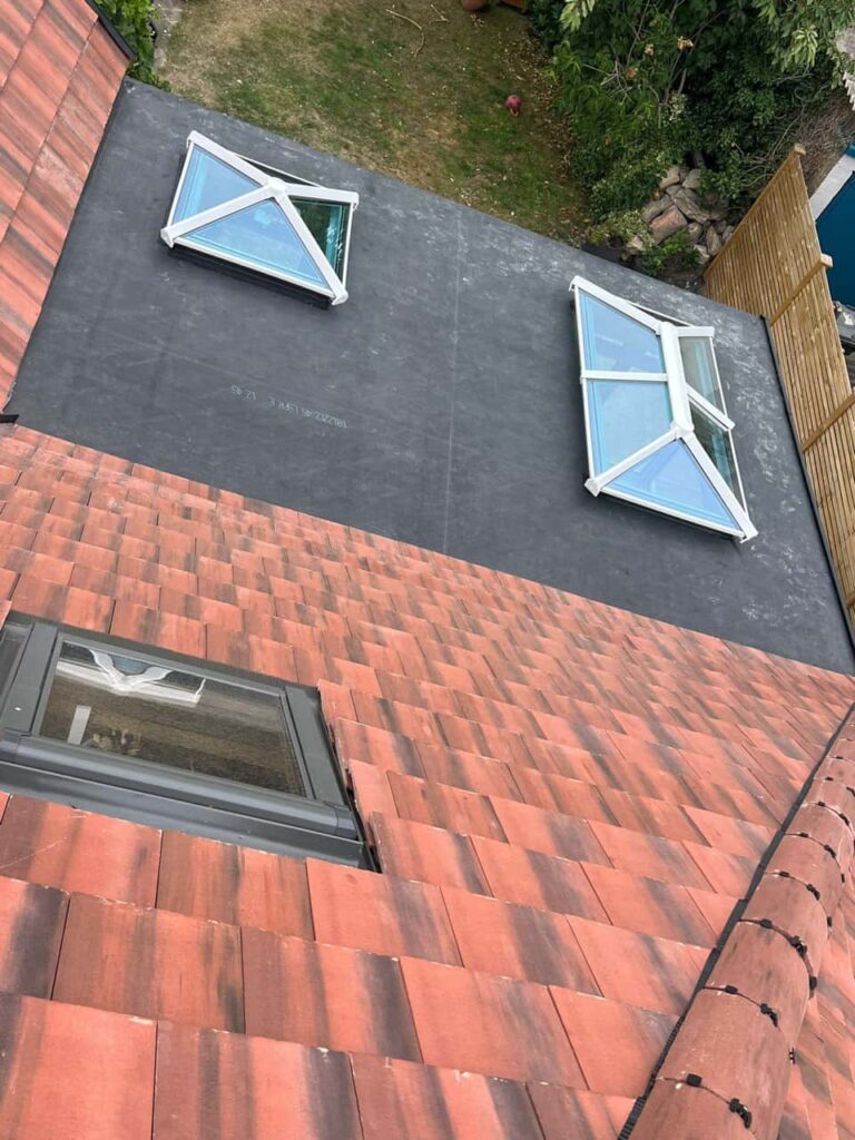 This is a photo taken from the roof ridge looking down a tiled pitched roof on to a flat roof. Works carried out by Radcliffe on Trent Roofing Repairs